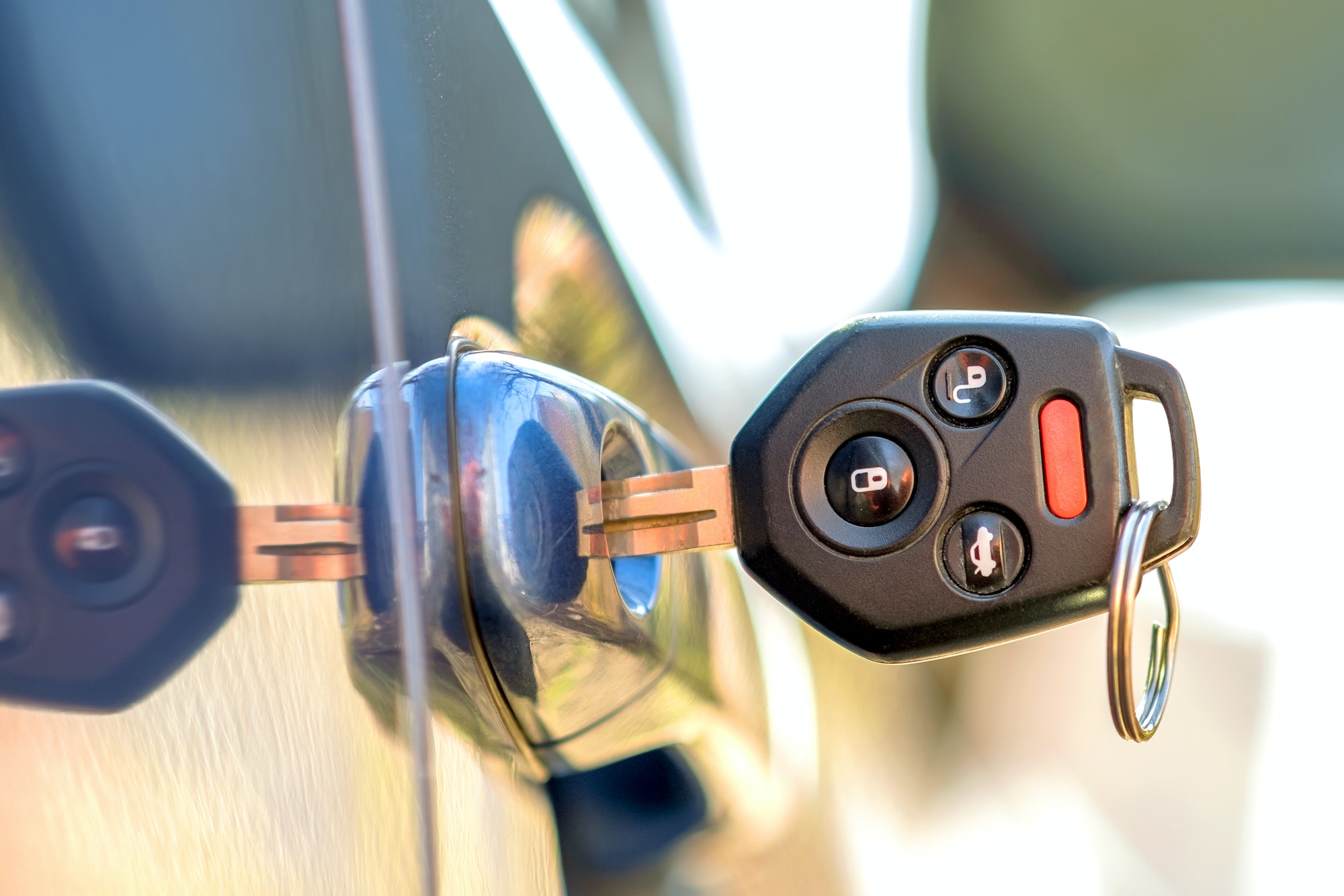 Close up of car door with key sticking out of the lock. Concept of process opening or closing