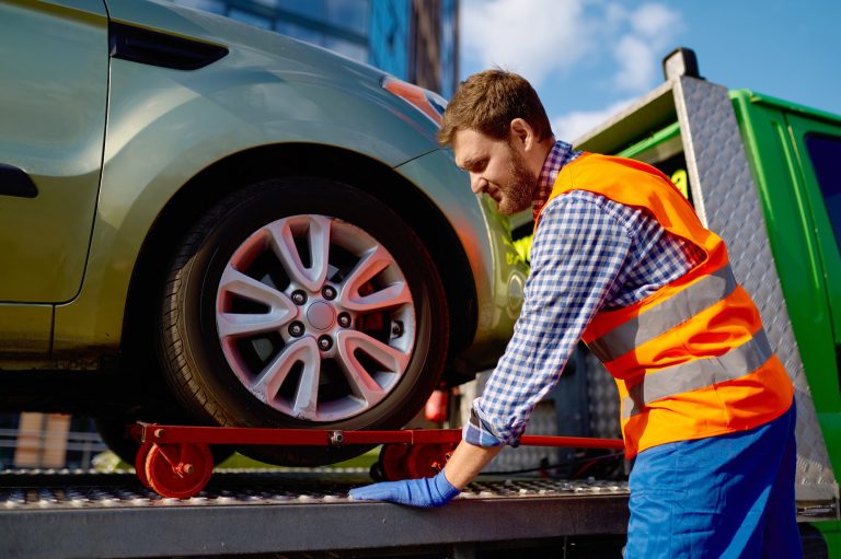 Tow truck operator fixing the car on platform